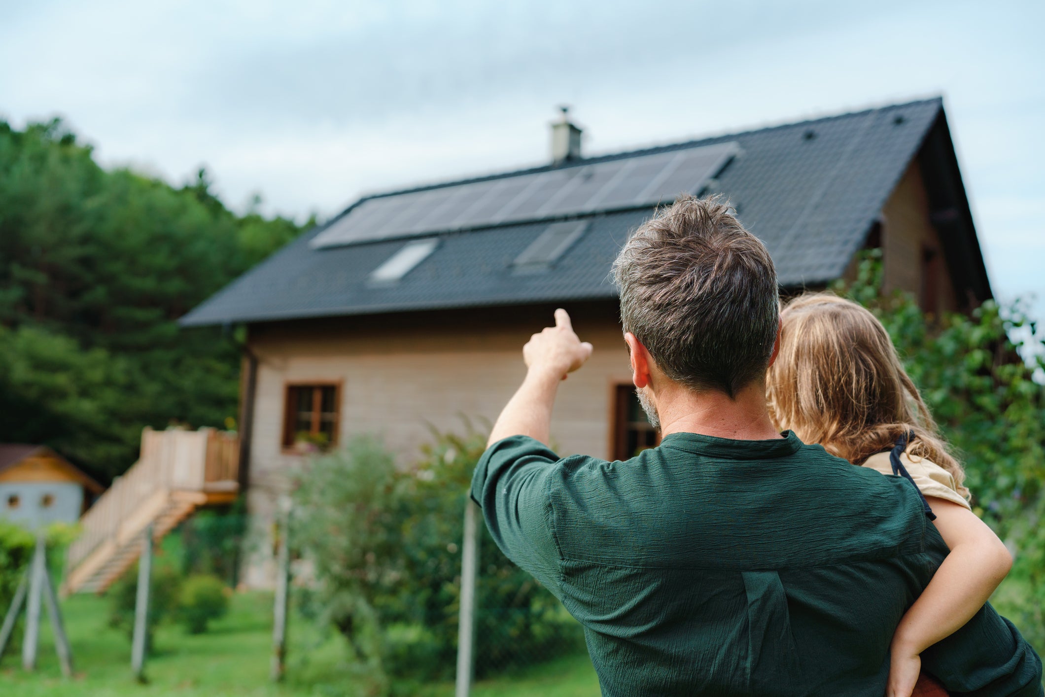 Father and child viewing a home with solar panels
