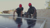 Two workers installing a solar panel.