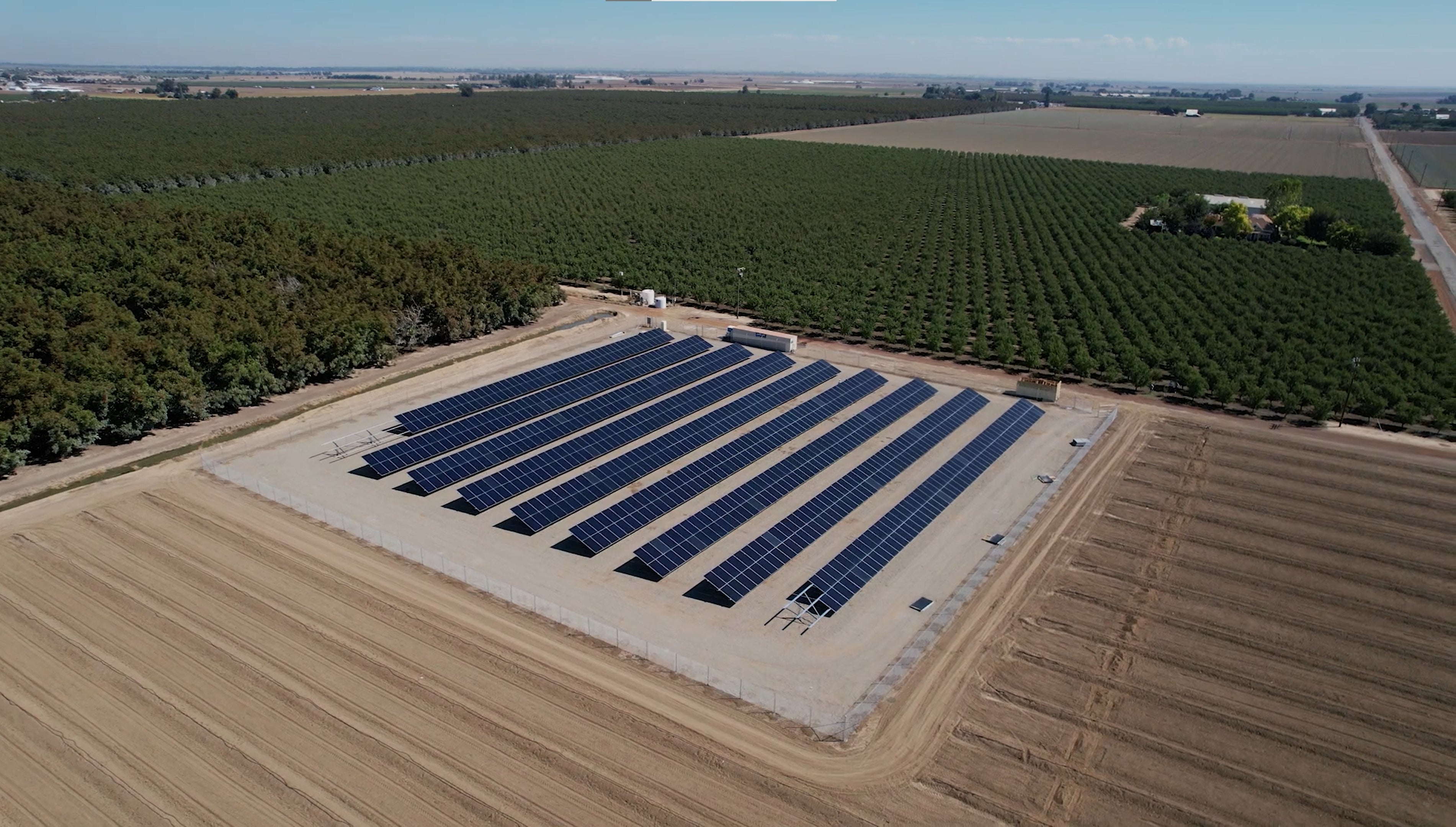 Solar installation in a field surrounded by orchards